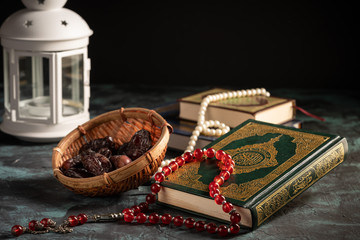 Islamic concept: The holy Quran and Tasbih (rosary beads) on dark background
