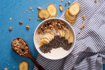Healthy pineapple, mango smoothie bowl with coconut, bananas, blueberries and granola. Top view scene on a bright background.