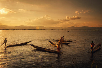Naklejka premium Intha Burmese fishermen on boat catching fish traditional at Inle Lake, Shan State, Myanmar