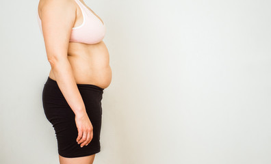 Woman with fat abdomen, overweight female stomach, stretch marks on belly closeup, white background
