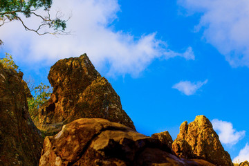 Yellow-brown rocks on bright blue sky background. The hanging rocks, Victoria, Australia.