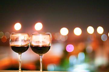 Two glasses of wine on a night city lights background.