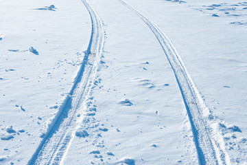Two tracks from car treads in the snow.