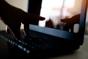 Cyber crime hand reaching out through laptop computer, attack signifying internet theft while using...