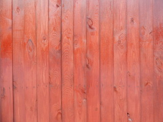 wooden surface coated with red matte varnish accentuating the texture