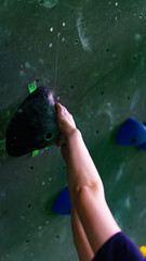 girl bouldering on rocks and grips