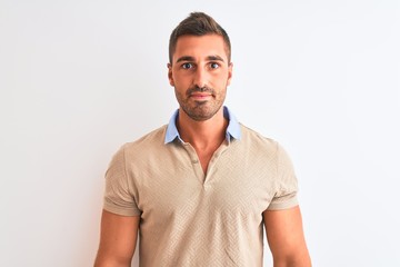 Young handsome man wearing elegant t-shirt over isolated background with serious expression on face. Simple and natural looking at the camera.
