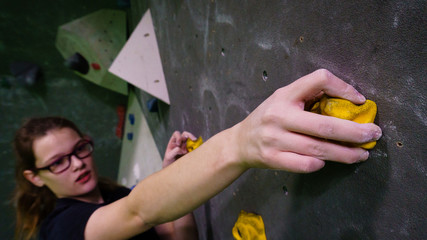 girl bouldering on rocks and grips