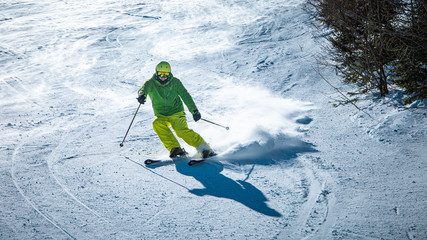 Male skier carving down a slope