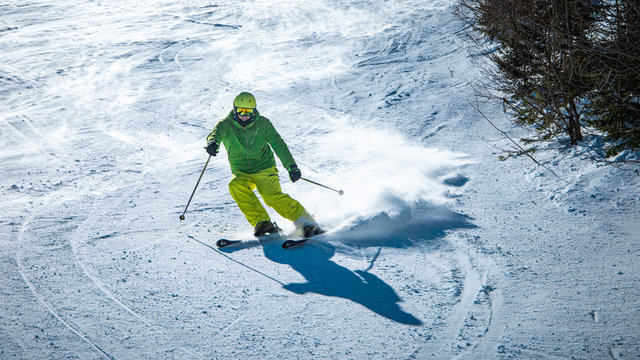 Male skier carving down a slope