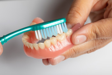 Fototapeta na wymiar Clean dental prothesis with toothbrush