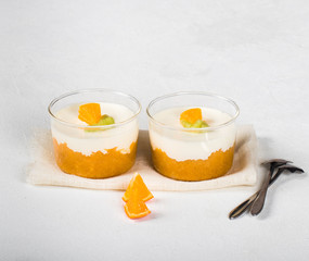 Vanilla Panna cotta in a glass Cup, Italian dessert creamy jelly with a tangerine layer, decorated...