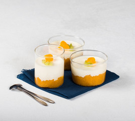 Vanilla Panna cotta in a glass Cup, Italian dessert creamy jelly with a tangerine layer, decorated...