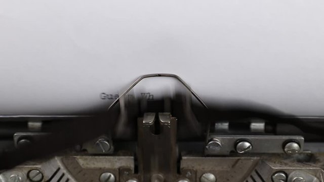 close-up typing text guess what, old vintage typewriter with a sheet of paper