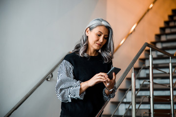 Calm lady on the stairs with her gadget stock photo