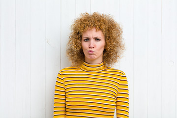 young pretty woman feeling confused and doubtful, wondering or trying to choose or make a decision