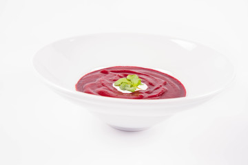 Beetroot cream soup decorated with coriander leaf and some cream