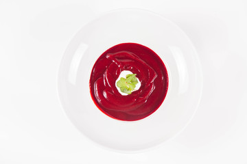 Beetroot cream soup decorated with coriander leaf and some cream