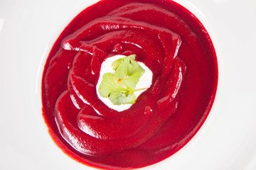Beetroot cream soup decorated with coriander leaf and some cream