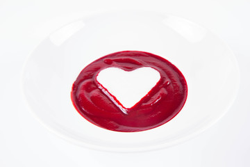Beetroot cream soup decorated with a heart made of yoghurt