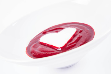 Beetroot cream soup decorated with a heart made of yoghurt