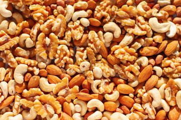 Background of a mixture of different nuts (cashew, peanuts, almonds, walnuts)