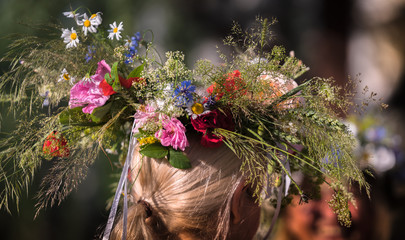 Naklejka premium summer solstice wreath on head, handmade, individual parts in focus, summer day