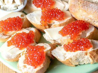 Bread and butter sandwiches with red caviar on a plate. Exquisite and expensive appetizer
