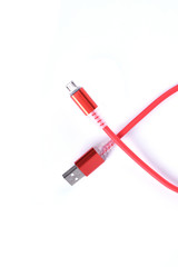 Red USB cable for smartphone charge isolated on white background.