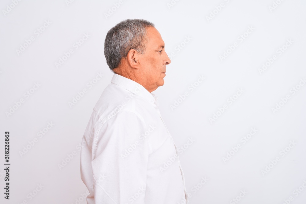 Sticker Senior grey-haired man wearing elegant shirt standing over isolated white background looking to side, relax profile pose with natural face with confident smile.