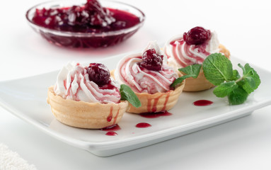 Homemade tartlets with cream cheese, cherry jam and mint
