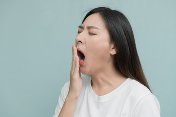 asian young Women yawn on light blue background.