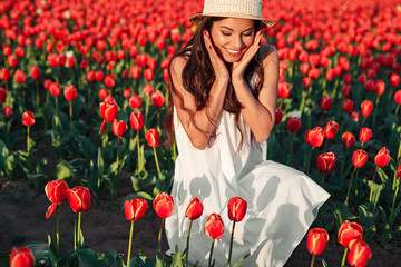 Happy woman admiring red tulips