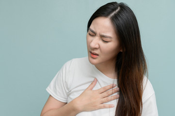Asian woman haveing The symptoms of acid reflux. Burning sensation in the chest. Her expression...