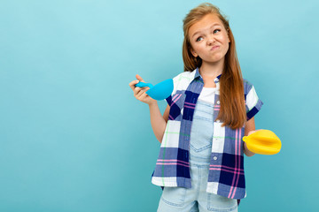 Teenager caucasian girl is going to cook something with kitchenware isolated on blue background