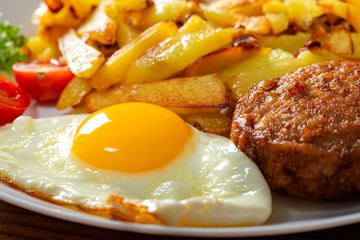 Fries with fried egg and one big meatball