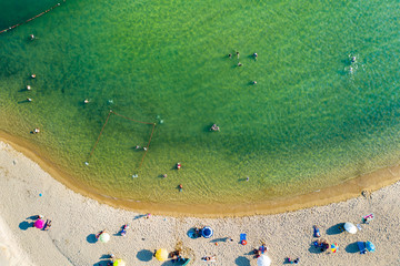 Aerial view from flying drone of people crowd relaxing on the beach in Greece.