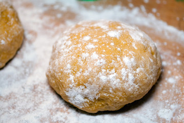 Fresh raw dough on a wood pastry board