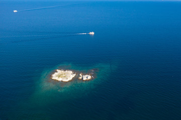 Aerial drone view of a remote rocky island in open sea.