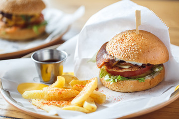 Lunch Time. Hamburger and fries with sauce isolated on table close-up