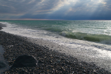 powerful sea surf. Huge wave. dramatic beautiful clouds. Spray against the sky. A wave covers. sun...