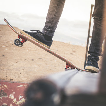 Close up view of teen's feet on a skateboard ready to start a ride over the half pipe. Skater starting jumps and tricks at the skate park. Let's go enjoying. Youth, future brave, danger, risk concept