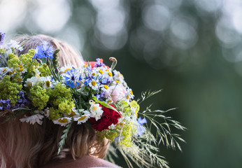 Naklejka premium summer solstice wreath on head, handmade, individual parts in focus, summer day