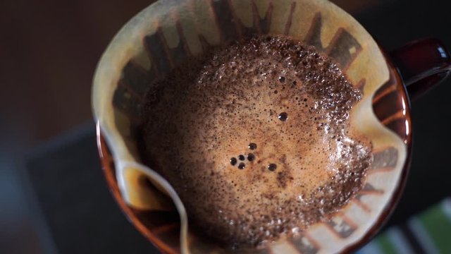 Closeup specialty coffe drip in pot. Rotating zoom-in slow motion