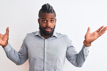 African american businessman with braids standing over isolated white background clueless and...