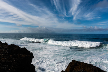 Dangerious ocean stormy waves hits black lava rocks by Faro de las Hoyas, La Palma island, Canary, Spain