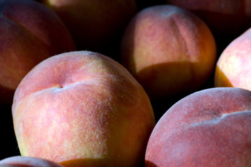 A group of ripe peaches in a bowl