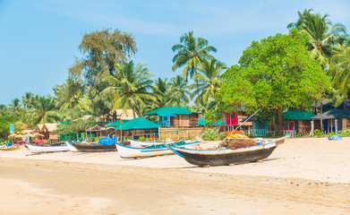 Beautiful beach view with fishing boat, yellow sand and blue ocean, Goa state in India