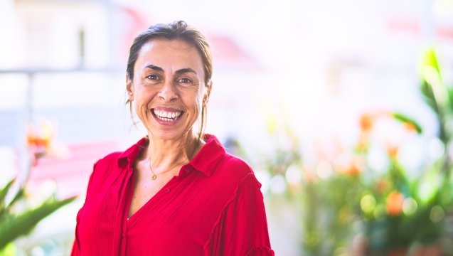 Middle age beautiful woman smiling happy and confident standing with a smile on face at terrace