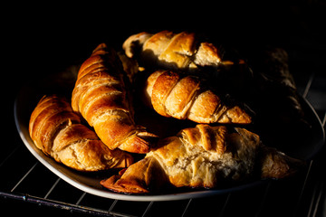 In the early morning, the sun's rays fall on the croissants. Freshly baked fragrant french breakfast.